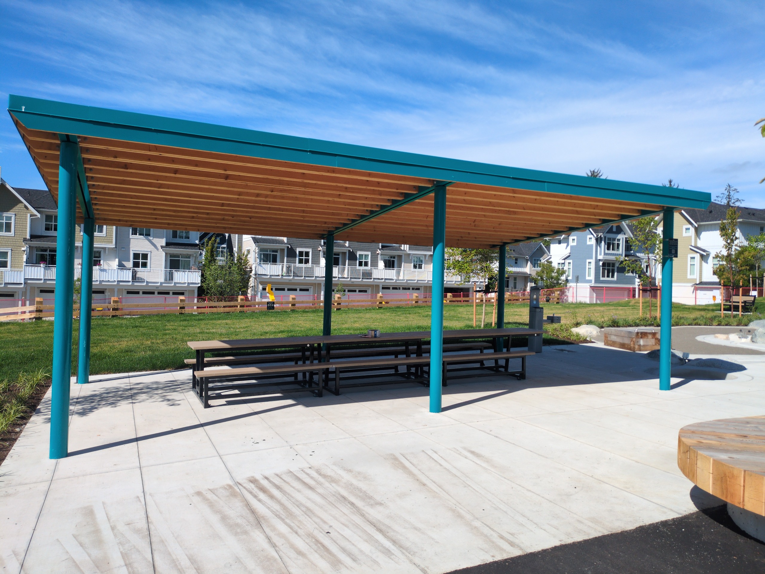 Teal metal picnic shelter with exposed wood ceiling