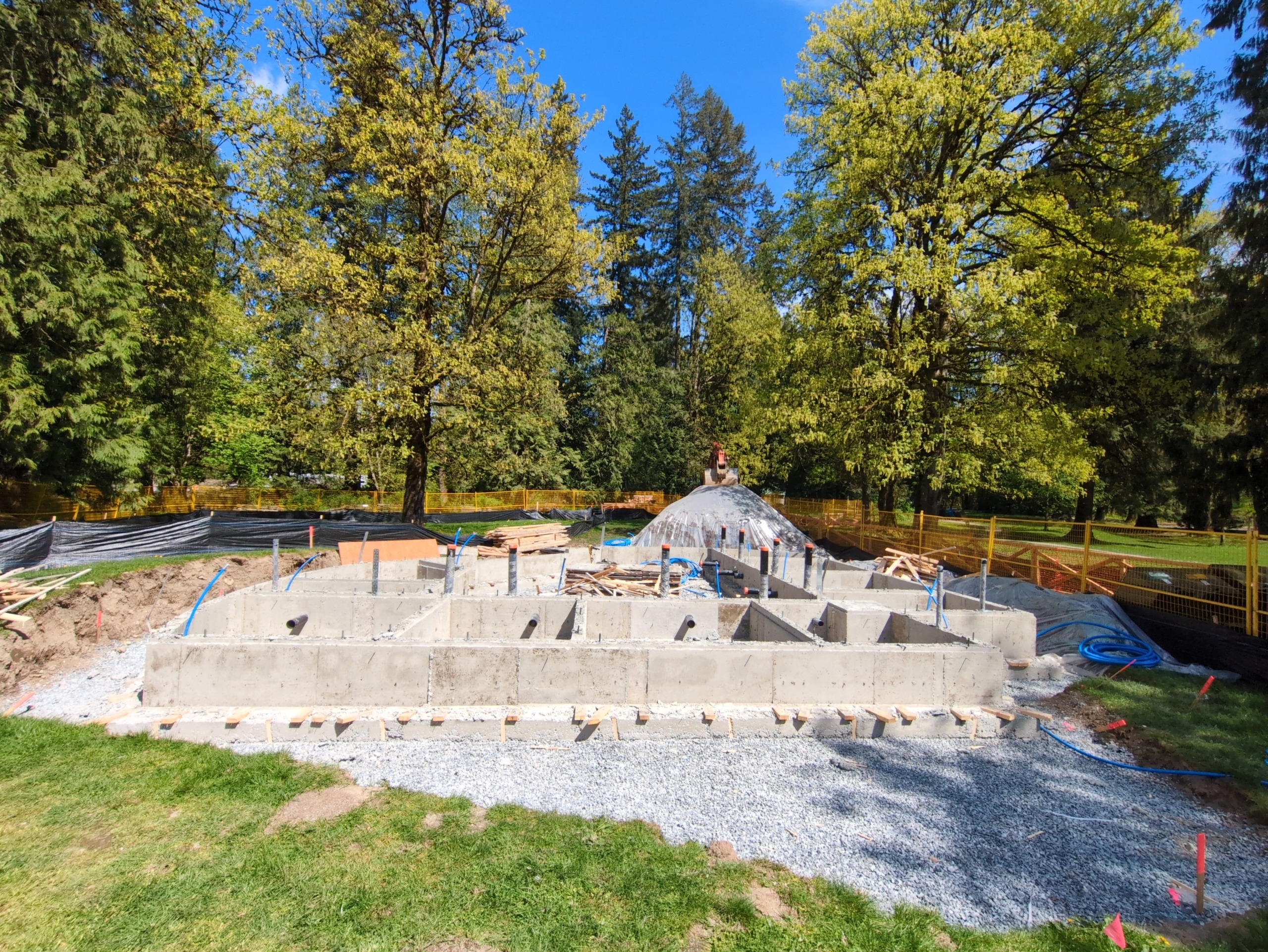 Washroom building foundation in progress surrounded by trees